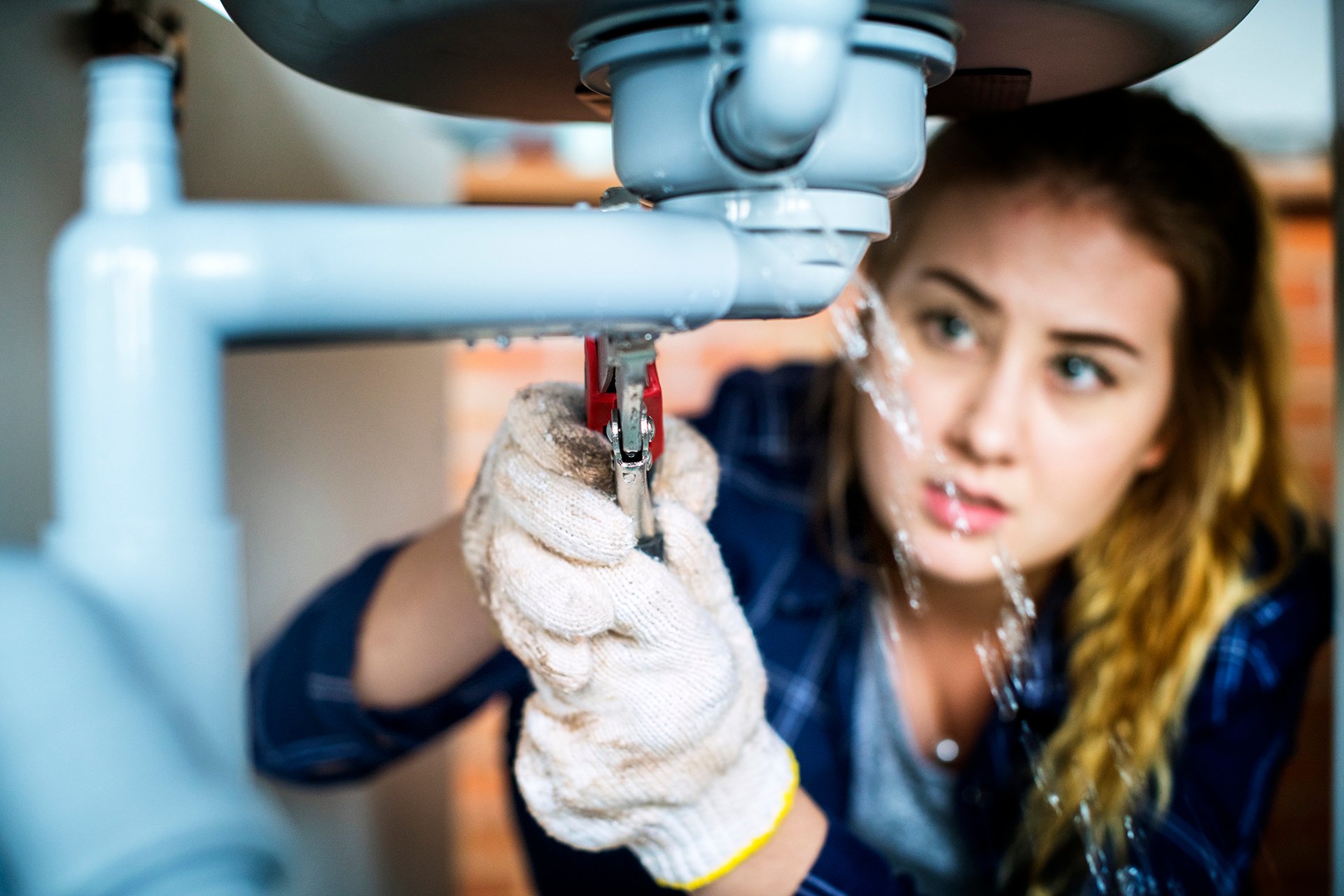 Woman fixing kitchen sink Woman fixing kitchen sink
